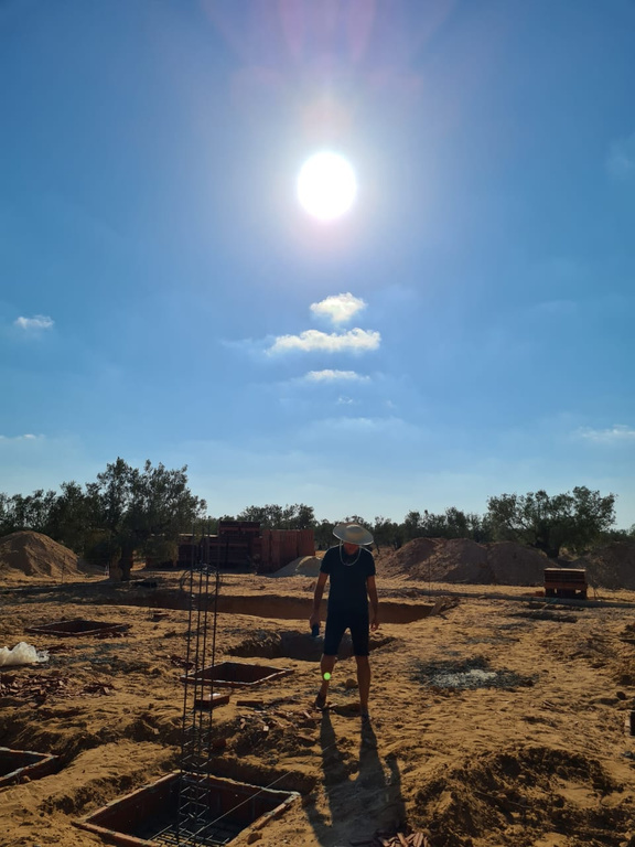 our head miller standing in the middle of the construction field with the sun in the background, supervising operations for the start of Dear Goodness Mill building. Best Olive Oil